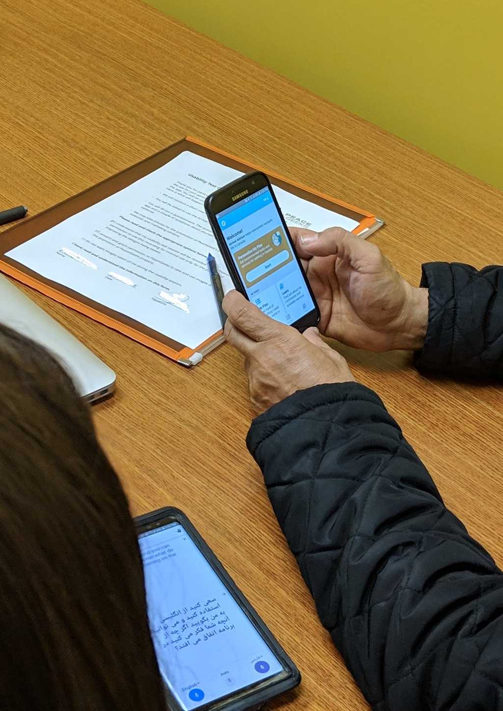 Usability testing of an early working prototype with a newcomer at a settlement agency. At times, we used translation apps and interpreters or same-language-speaking staff to help communicate with testers.